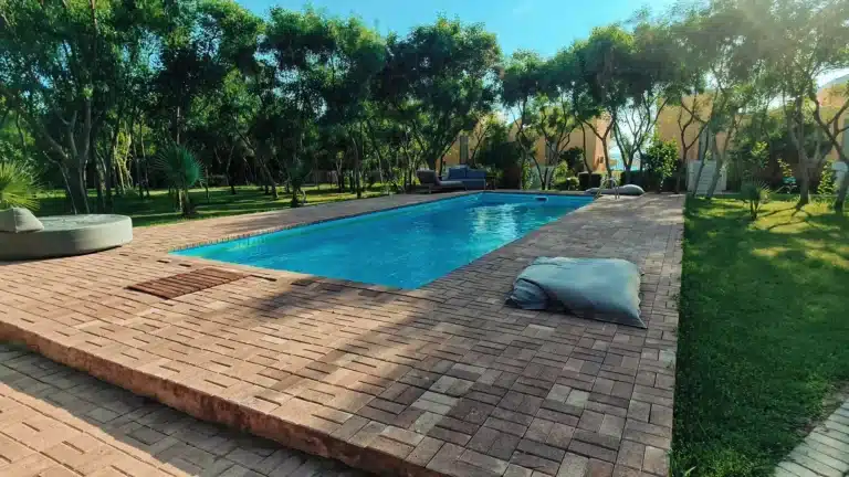 Pool 2 Enhance the wooden deck with rich, warm brown tones. Bring out the natural golden-brown wood grain, increasing color saturation slightly for a warm, sun-drenched look. Keep the original texture and lighting intact.